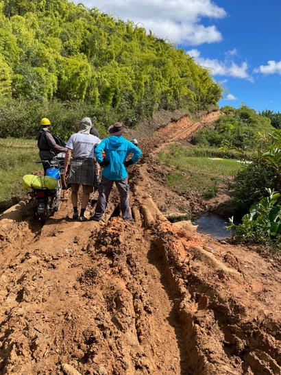 Unbefestigter Weg mit Motorrad und Menschen auf Madagaskar