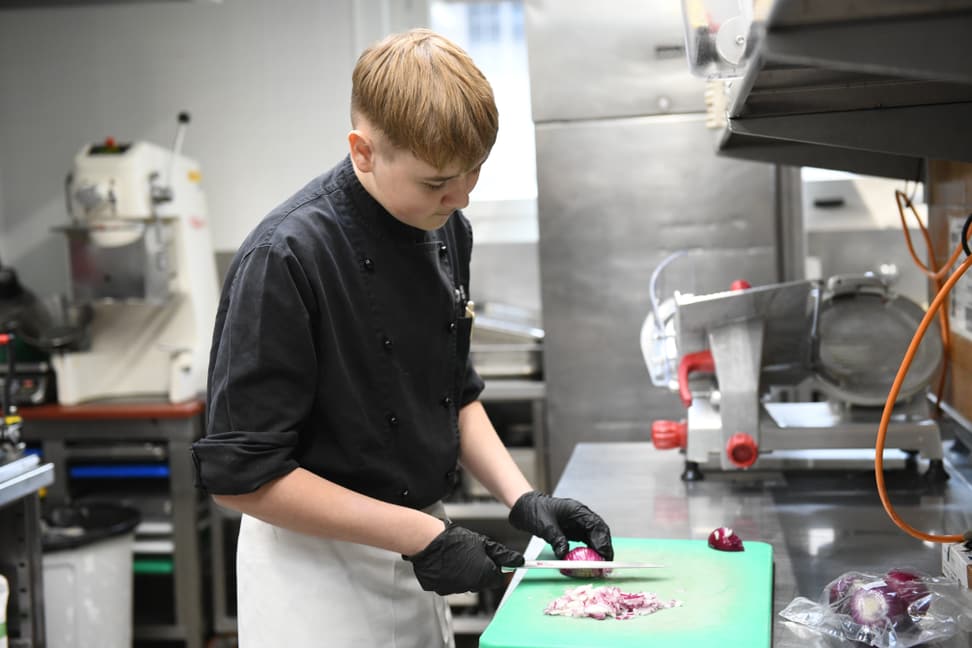 Kochlehrling im Zoo Zürich bei der Arbeit.