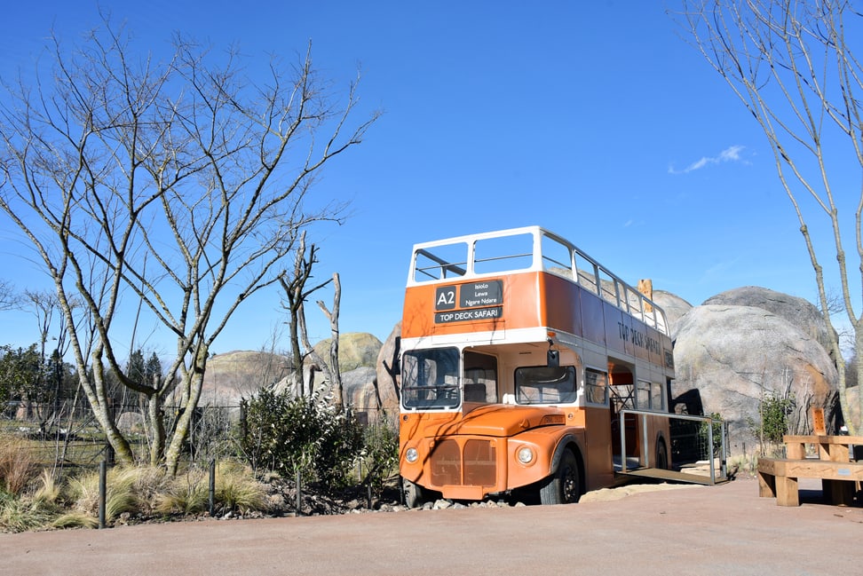 Safaribus und Kopjefelsen in der Lewa Savanne.