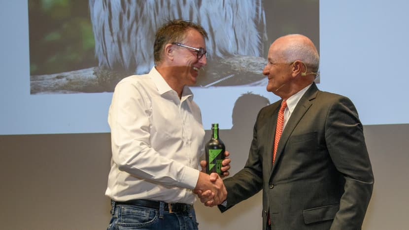 Kurt Plattner, früherer Leiter Finanzen & Controlling, erhält von VRP Martin Naville einen Kifaru Gin an der Aktionariatsinformationsveranstaltung 2022 im Careum.