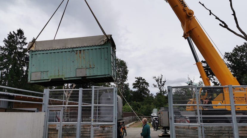 Ein Kran transportiert die Transportkiste vom Lastwagen vor den Eingang zur Quarantänebox.